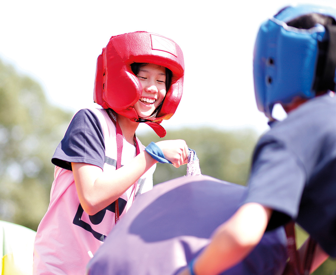 Female Student Smiling at Camp Dragon Playing with Inflatables