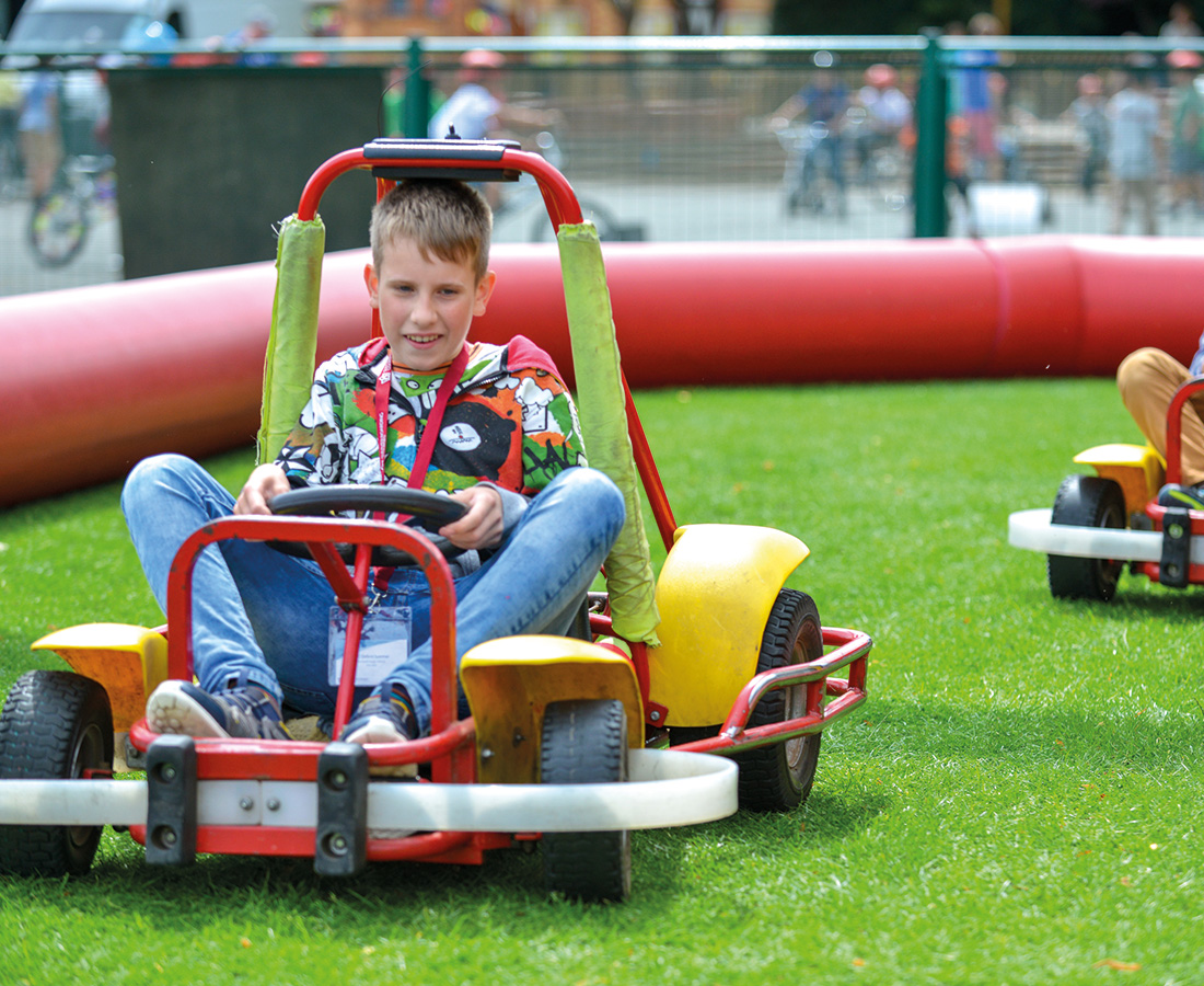 Male student go carting at camp dragon